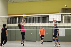Frau schlägt Volleyball übers Netz