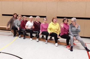 ältere Frauen sitzen hintereinander auf einer Bank