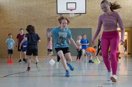 Kinder laufen in der Turnhalle